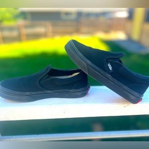 Kids slip on black vans.